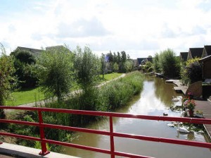 foto van een gebogen waterloop met daarnaast een fietspad